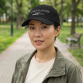 Woman wearing the black Healing Loading Cap in a leafy park